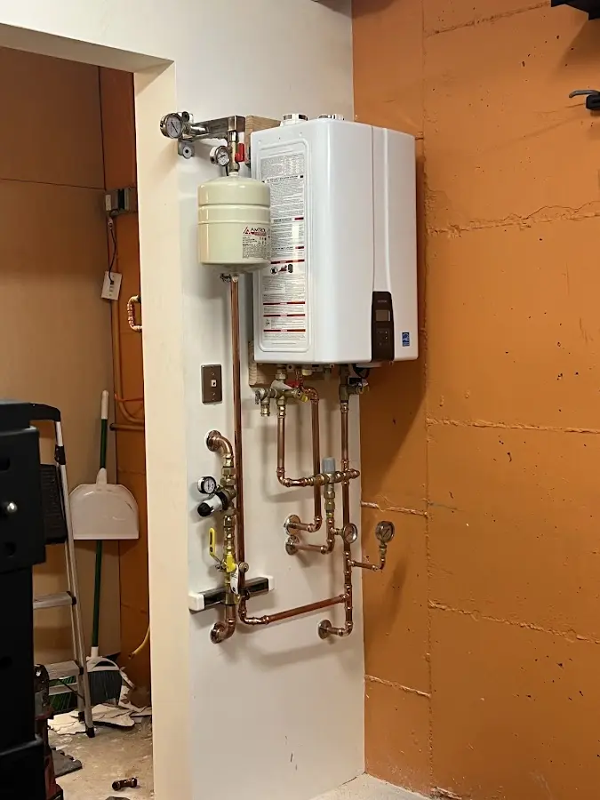 Plumbing technician inspecting water heater connections in Gardere
